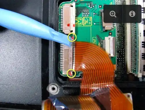 Remove the ribbon cable farthest from you. Push the white tab to release the ribbon cable